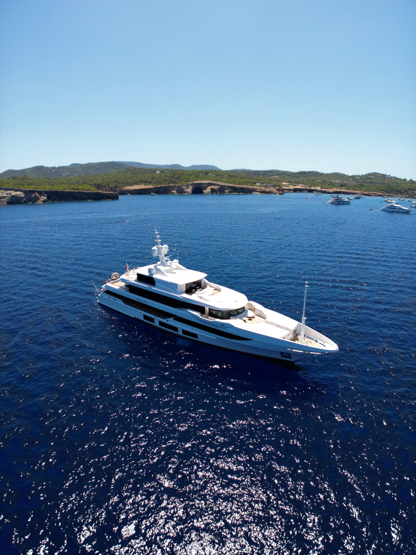 Motor yacht Surpina at anchor in a Mediterranean bay